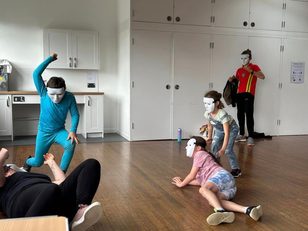 This image shows young people acting with masks.