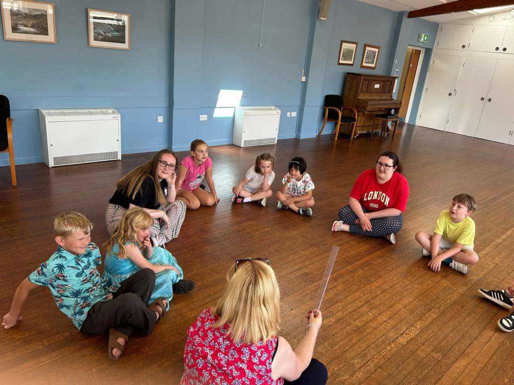 Stagezone children playing drama games using a ruler.