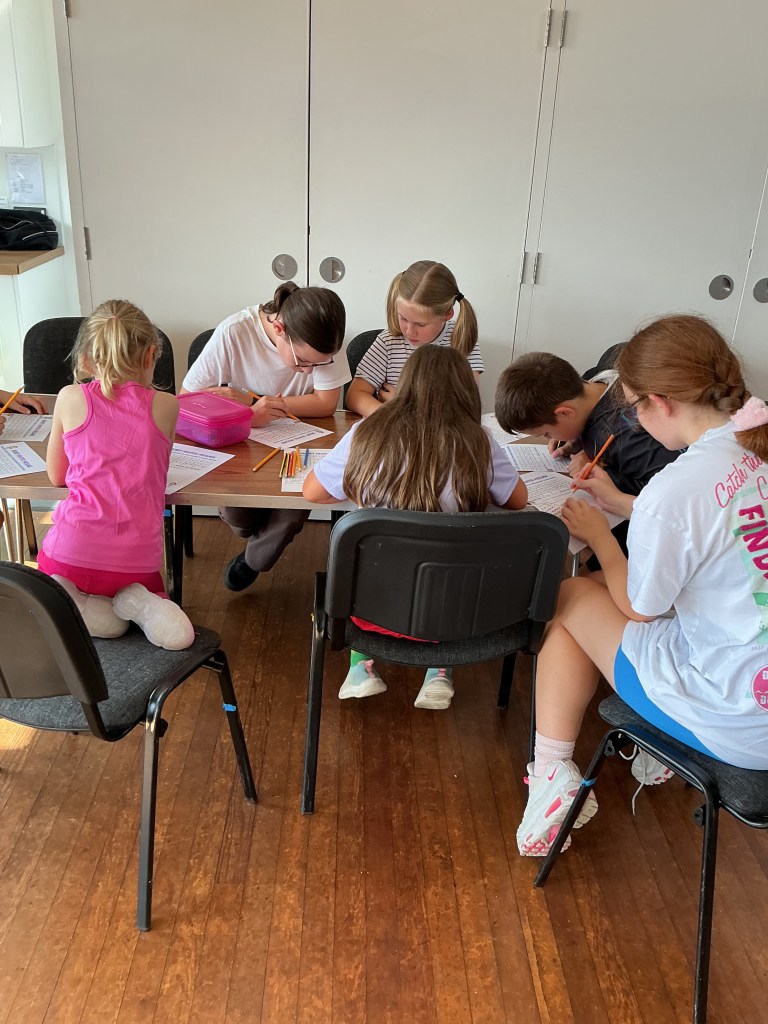 A photo of Stagezone members completing a Demon Hunter Code worksheet